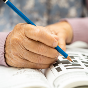 Ouder persoon die een puzzel doet